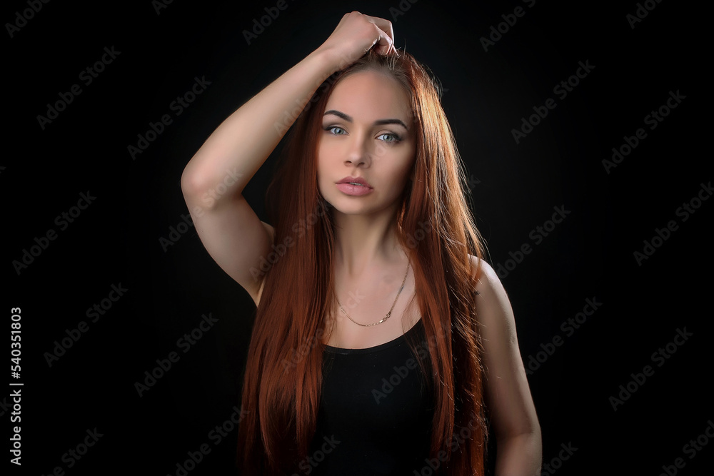 portrait of a beautiful young red-haired girl on a dark black background in the studio, with a cleavage and big breasts in black portrait of a beautiful young red-haired girl on a dark black background in the studio, with a cleavage and big breasts in black