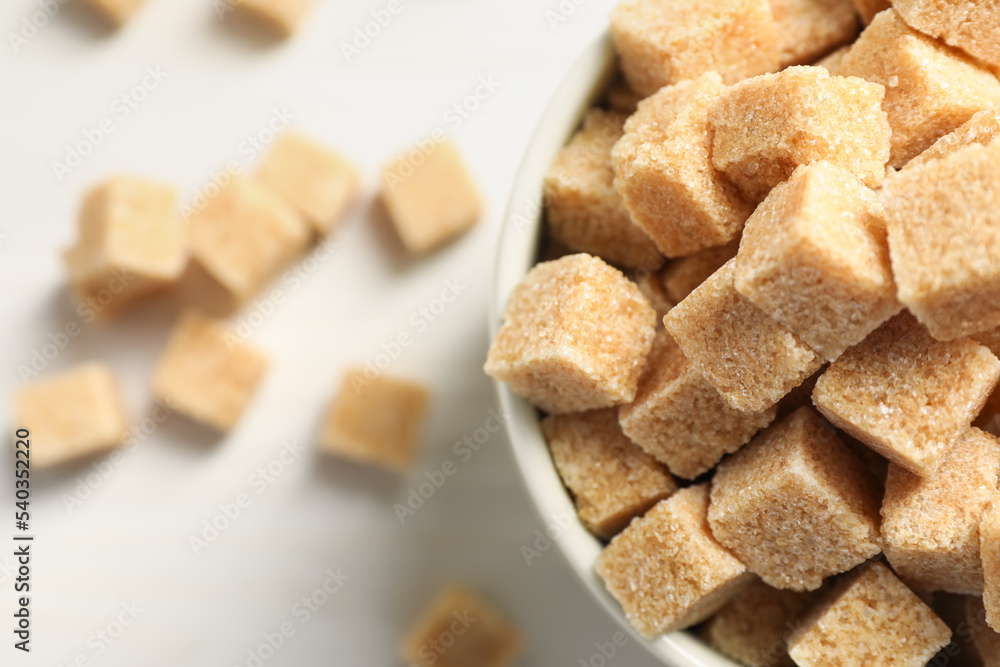 Brown sugar cubes on white table, top view. Space for text