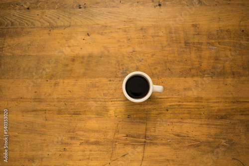 Coffee cup on the old wood rustic desk.