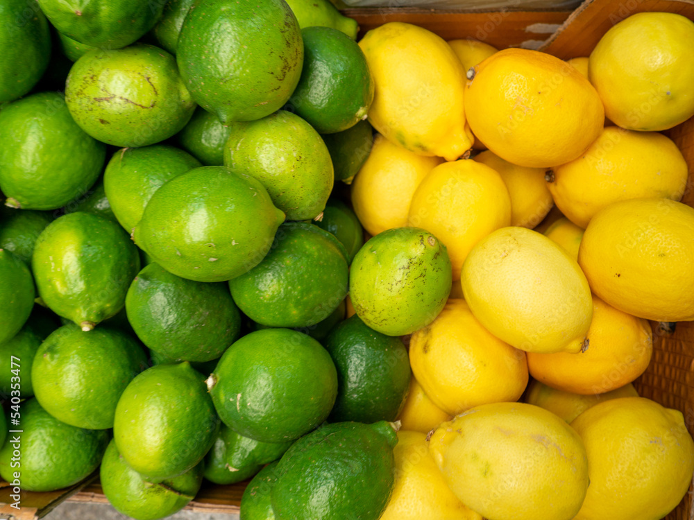 Lemons and limes in one box. Background from different citrus fruits. Yellow and green fruits.  Citrus concept. in the eastern market