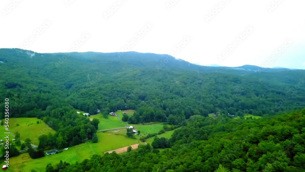 Aerial Panning Beautiful View Of Houses Amidst Green Mountains Against Clear Sky - Asheville, North Carolina