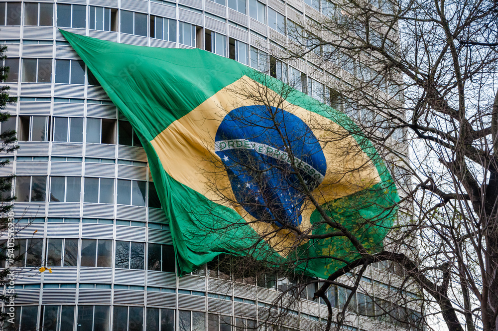 a bandeira do Brasil tremulando do alto de um prédio - obrazy, fototapety, plakaty 