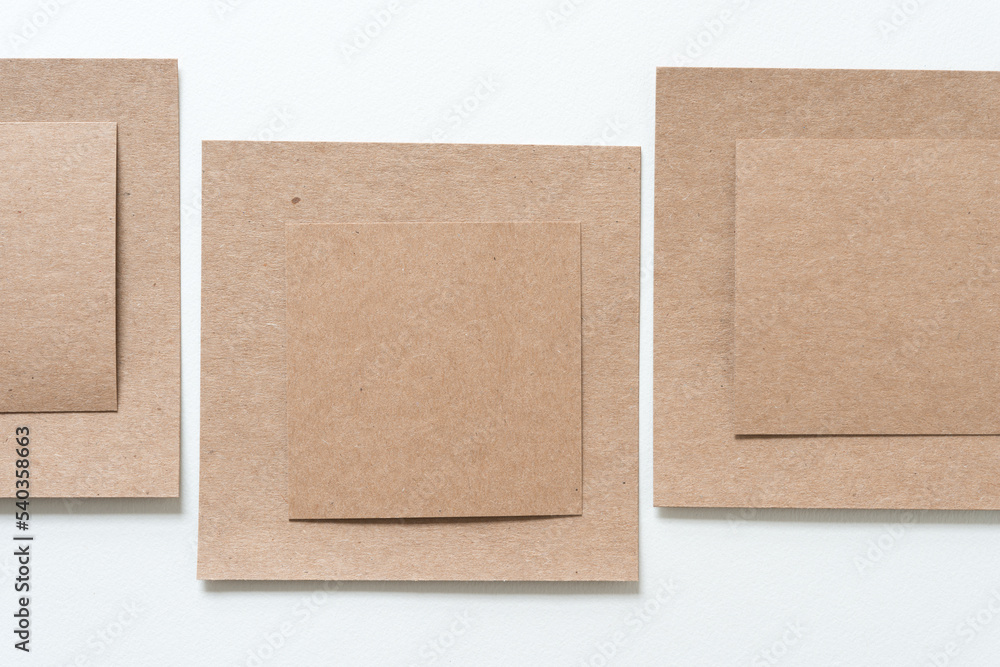 Fototapeta premium layered plain brown paper cardboard shapes on blank paper