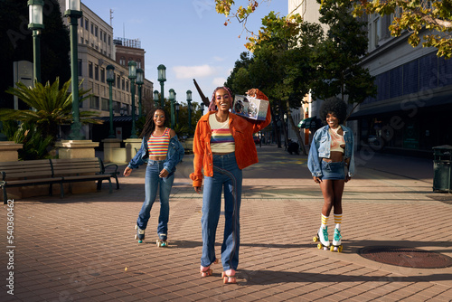 Portrait of young friend group together in the city on rollerskates

