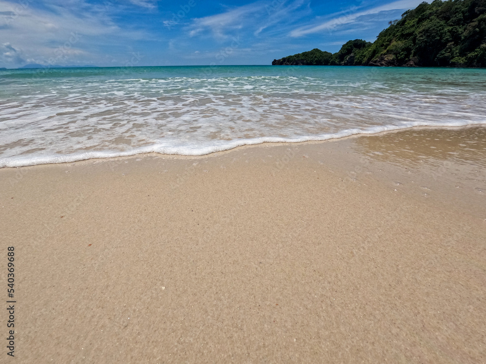 Light blue ocean waves on clean sandy beach. Natural scenery of beautiful tropical beaches and sea on a clear day. Light blue ocean waves on clean sandy beach. Natural scenery of beautiful tropical beaches and sea on a clear day.