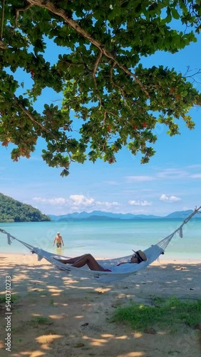 A couple of men and women in a hammock on a tropical beach in Koh Mak TratThailand photo