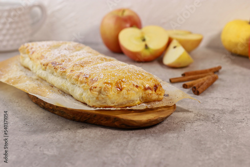 apple pastry strudel roll with cinnamon on grey marble table photo