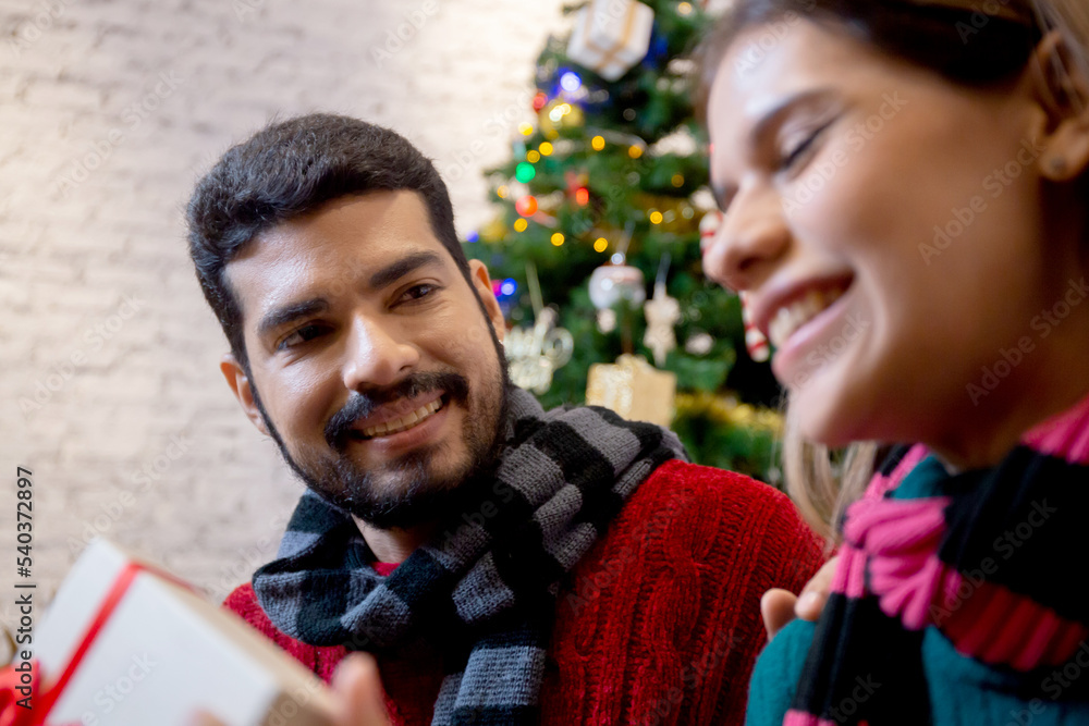 Young man giving presents for surprise girlfriend in celebration Christmas together at home, boyfriend giving gift woman with excited, event and festive x-mas, xmas and new year or holiday concept. Young man giving presents for surprise girlfriend in celebration Christmas together at home, boyfriend giving gift woman with excited, event and festive x-mas, xmas and new year or holiday concept.