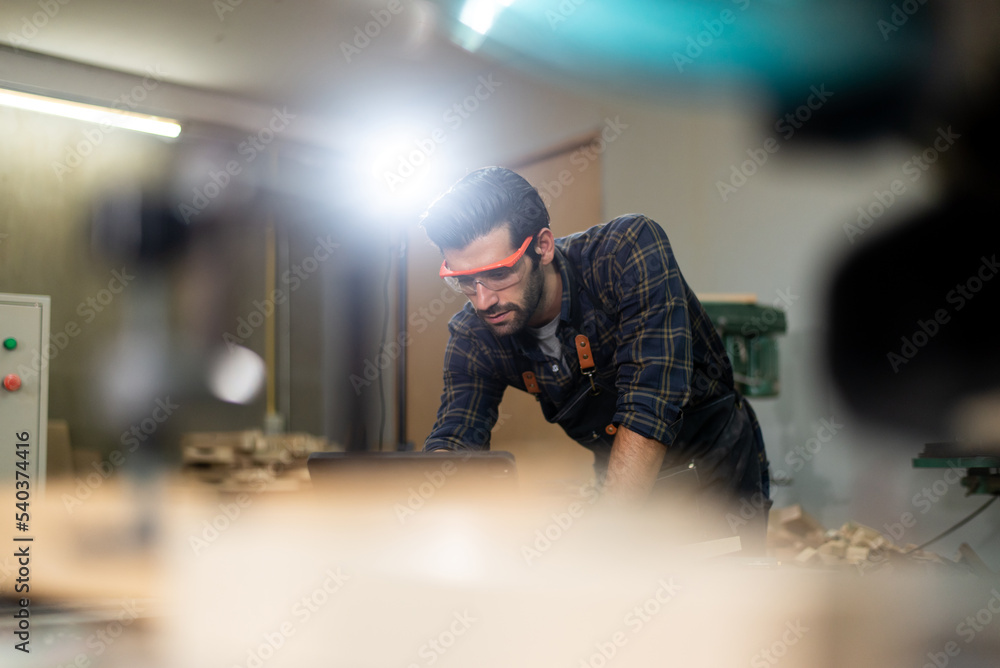 Carpenter men with bearded wearing glasses and working in wood workshop Carpenter men with bearded wearing glasses and working in wood workshop