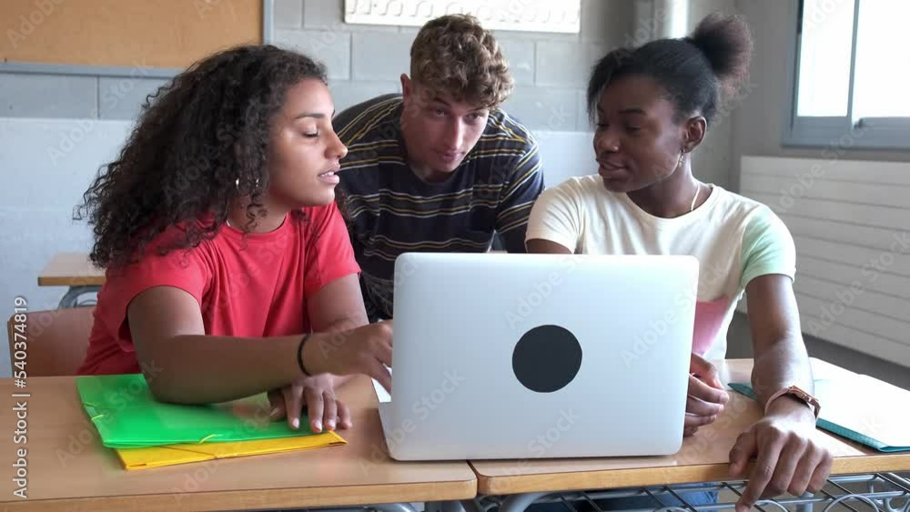 Multiracial group of high school students doing homework research together using laptop in class. 4k handheld video. Multiracial group of high school students doing homework research together using laptop in class. 4k handheld video.