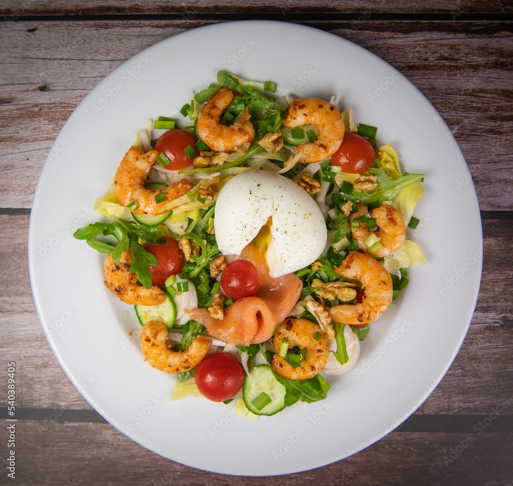 Recipe for rocket salad, endive, tomato, cucumber, soft-boiled egg, fried shrimp with paprika, smoked salmon and nuts. High quality photo Recipe for rocket salad, endive, tomato, cucumber, soft-boiled egg, fried shrimp with paprika, smoked salmon and nuts. High quality photo