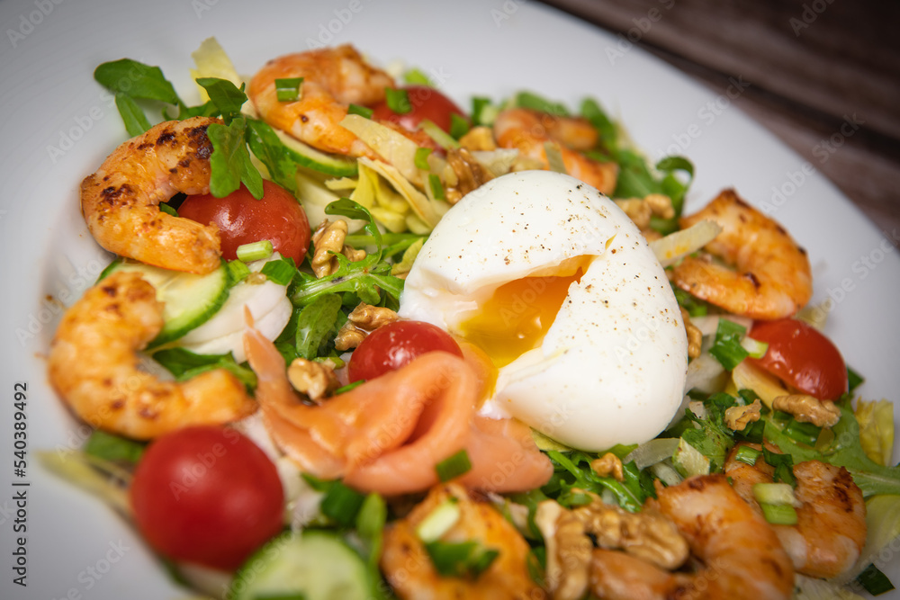Recipe for rocket salad, endive, tomato, cucumber, soft-boiled egg, fried shrimp with paprika, smoked salmon and nuts. High quality photo Recipe for rocket salad, endive, tomato, cucumber, soft-boiled egg, fried shrimp with paprika, smoked salmon and nuts. High quality photo