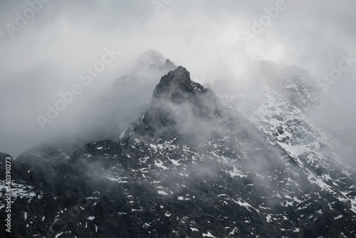 Dramatic scenery of rocky mountain peaks in clouds. Rysy and Niznie Rysy in the High Tatras. Carpathians, Poland