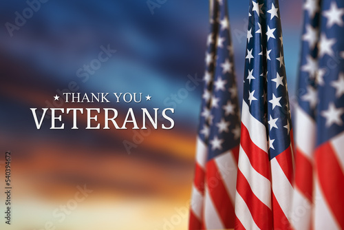 American flags with Text Thank You Veterans on sunset background. American holiday banner.
