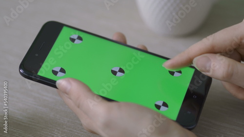 Woman Using Phone with Green Screen. Easy for tracking and keying.