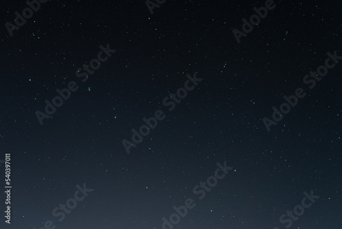 Many stars on black sky at night. A real dark night sky with plenty of stars. Night sky background with selective focus