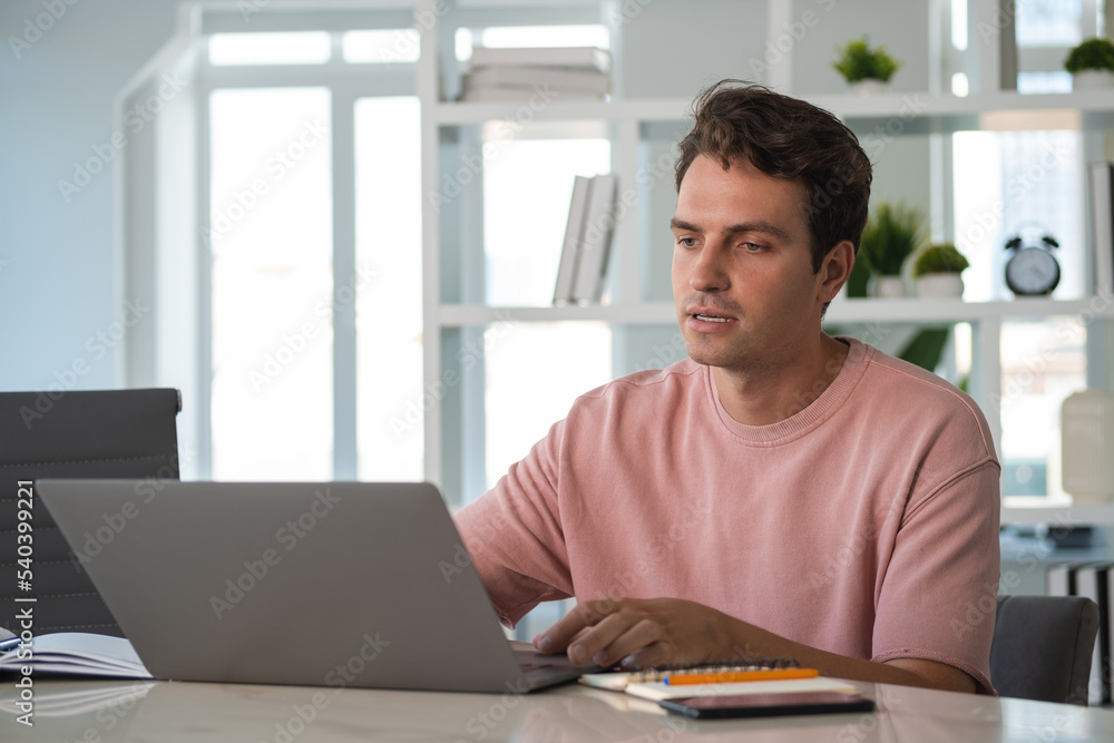 Young man student on a video conference, talking in office room Young man student on a video conference, talking in office room