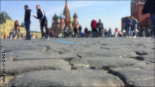 Blurred video of tourists walking on Red Square. Close-up Red Square pavings. Moscow landmarks: Saint Basil's Cathedral and Kremlin. Crowd of people on Red Square. photo