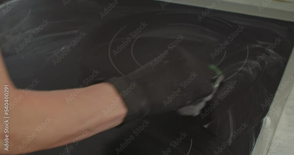 Cleaning the electric stove from carbon deposits, Close-up view Cleaning the electric stove from carbon deposits, Close-up view
