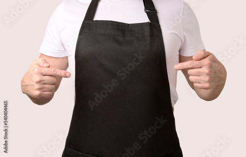 Fototapeta Chef cook pointing on black apron