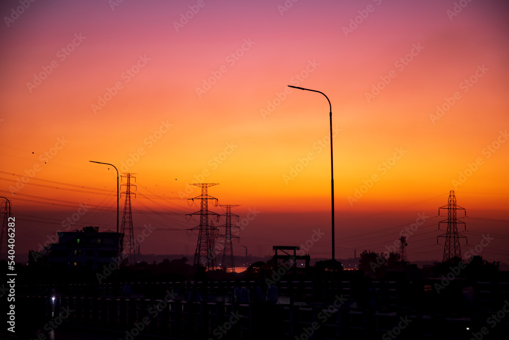 High Voltage electric pylons with colorful landscapes after sunset