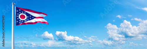 Ohio, USA - flag waving on a blue sky in beautiful clouds - Horizontal banner