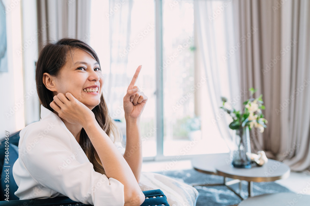 smiling woman got bright idea pointing up. asian female person thinking demonstrated people in living room with funny gesture act happy. beautiful woman having a wonderful thought idea showing pose