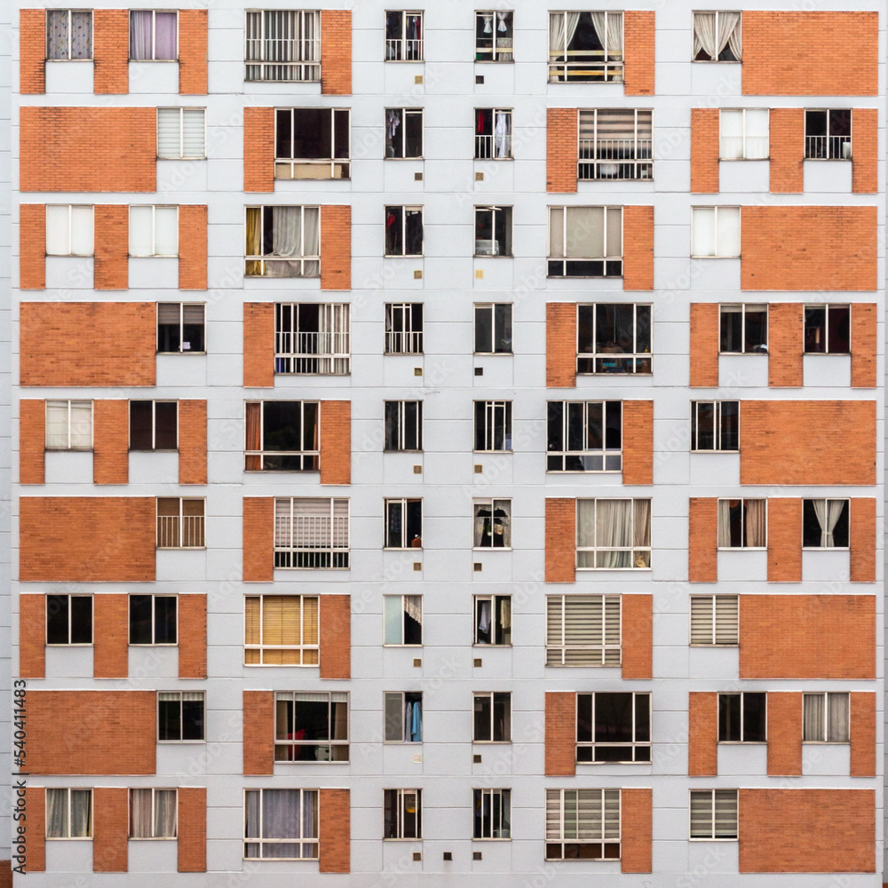 Building facade with many windows and curtains. The building is made of bricks. Beautiful geometric composition, Bogota, Colombia.