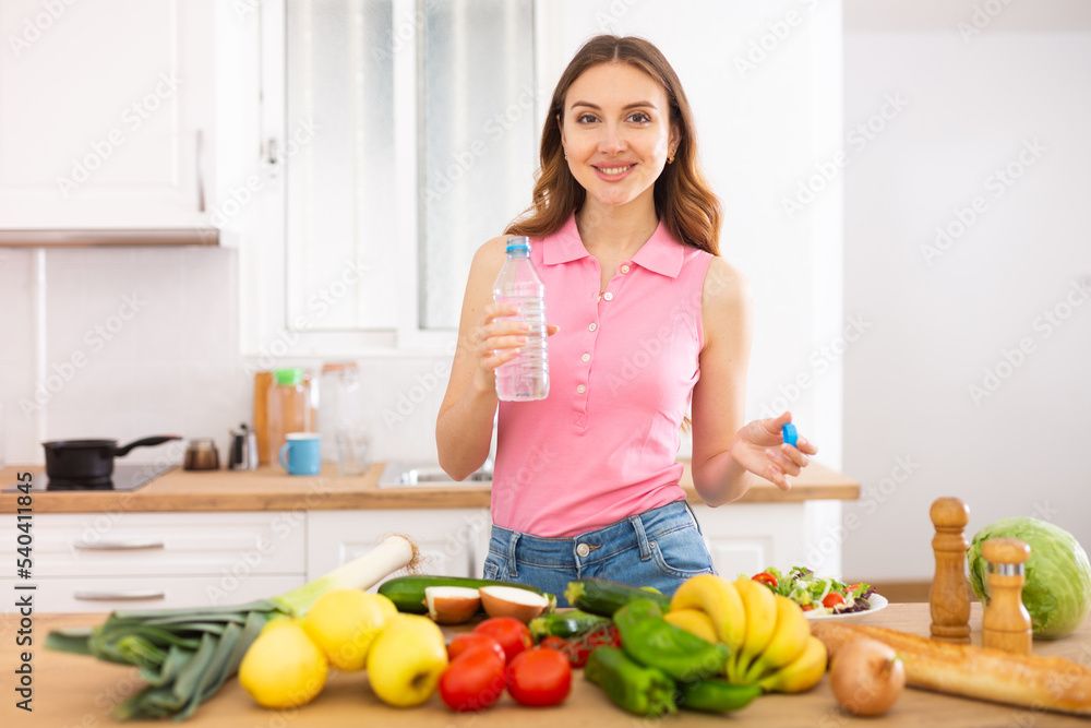 Attractive woman drinking water in the kitchen before breakfast
