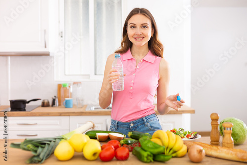 Attractive woman drinking water in the kitchen before breakfast