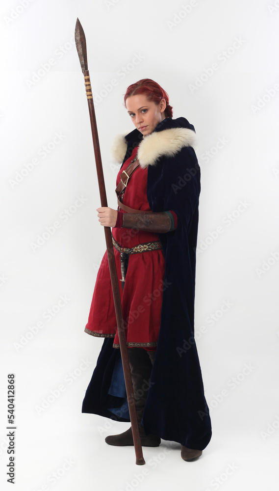 full length portrait of beautiful woman wearing a red medieval fantasy warrior costume with leather armour, holding weapons. Standing pose isolated on white studio background. full length portrait of beautiful woman wearing a red medieval fantasy warrior costume with leather armour, holding weapons. Standing pose isolated on white studio background.