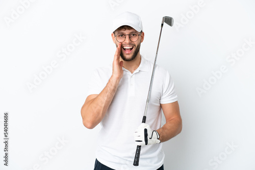 Handsome young man playing golf isolated on white background with surprise and shocked facial expression