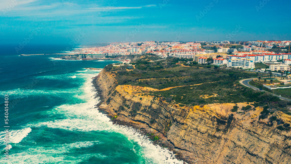 Drone  view over long rocky coastline in Ericeira, Portugal, on summer sunny day.  Top view - Beautiful natural landscape with ocean rocky shore. Aerial view over Scenic European tourist destination.