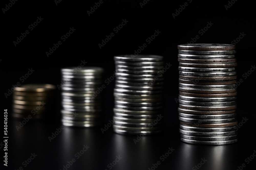 Stacks of metallic coins on a dark background Stacks of metallic coins on a dark background