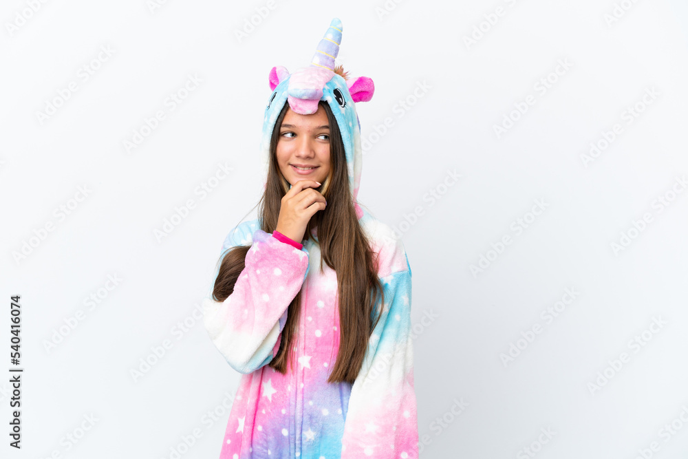 Little caucasian girl wearing unicorn pajama isolated on white background looking to the side Little caucasian girl wearing unicorn pajama isolated on white background looking to the side