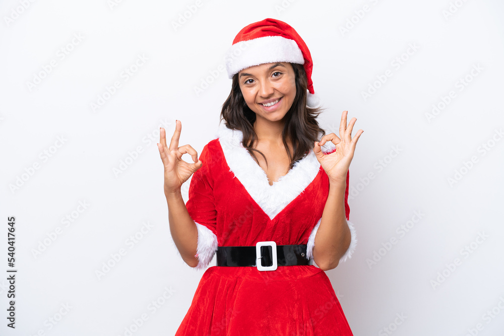 Young hispanic woman dressed as mama noel isolated on white background showing an ok sign with fingers Young hispanic woman dressed as mama noel isolated on white background showing an ok sign with fingers