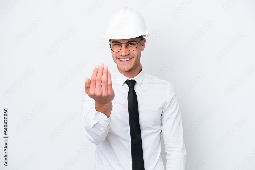 Young architect caucasian man with helmet and holding blueprints isolated on white background inviting to come with hand. Happy that you came Young architect caucasian man with helmet and holding blueprints isolated on white background inviting to come with hand. Happy that you came