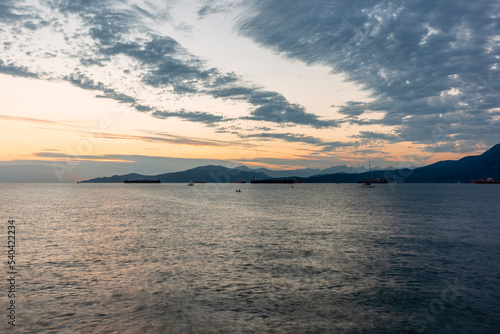 Sunset on the sea in front of Vancouver with container ships  sail boat and stand-up paddles