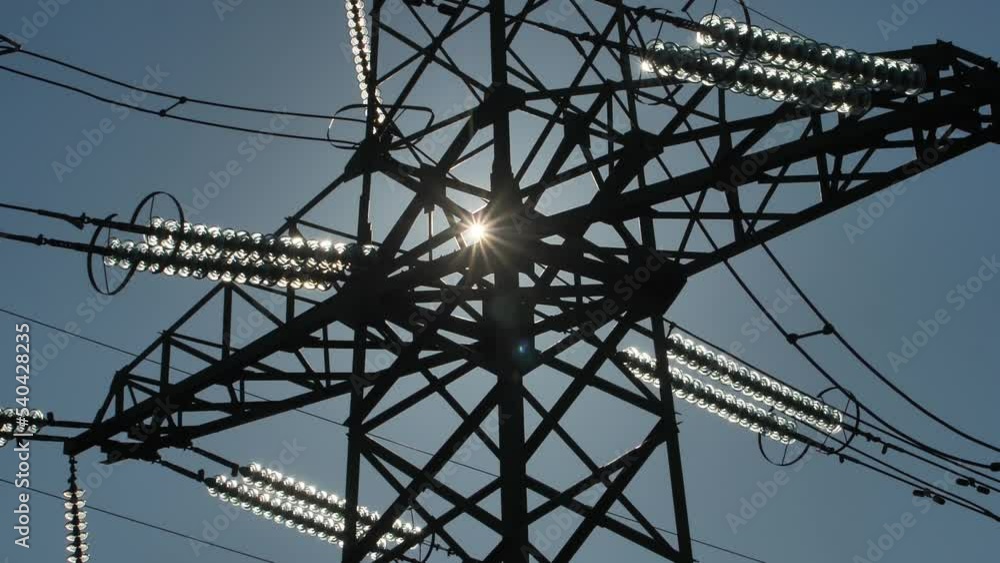 Power lines with sun rays on blue sky. High voltage substation. Electricity crisis in the world. Green energy in power lines. Selective soft focus Power lines with sun rays on blue sky. High voltage substation. Electricity crisis in the world. Green energy in power lines. Selective soft focus