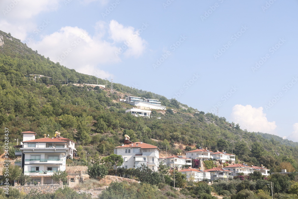 Mountainside houses with Mediterranean design, surrounded by plants and trees. Turkey.