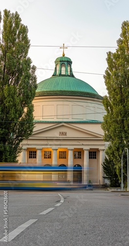 Vertical shot of the Ostfriedhof Cemetery with the bus in a motion blur in front