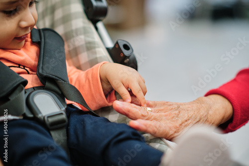Young child holding his grandmother s hand with affection. Focus on hands
