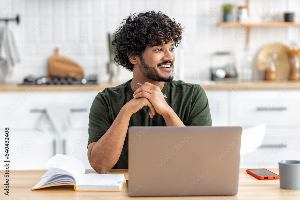 Distance learning. Portrait of smiling young Asian male freelancer or student sitting at home using laptop computer for online education Distance learning. Portrait of smiling young Asian male freelancer or student sitting at home using laptop computer for online education