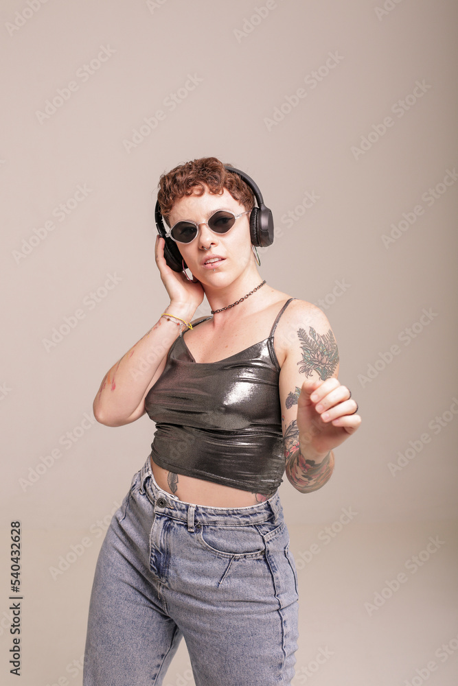 Portrait of a girl in front of a background, holding a phone, listening to music Portrait of a girl in front of a background, holding a phone, listening to music