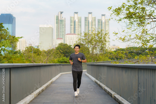 Asian healthy athlete man jogging at morning in public city park the city.