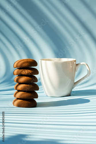 Cup of hot coffee and sweet cookies on blue background. Biscuit, pastry. Top view, copy space, mockup. Flat lay. Food and drink.