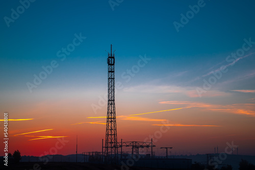 relay Cell tower in the early morning against the background of an orange sky