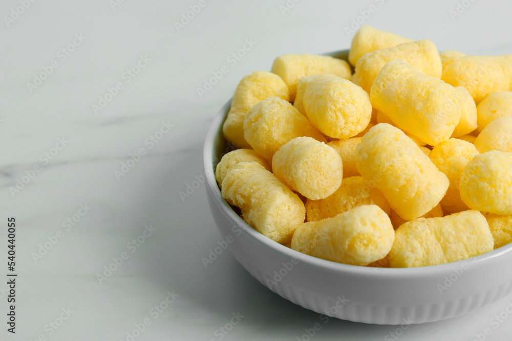 Bowl of delicious crispy corn sticks on white marble table. Space for text Bowl of delicious crispy corn sticks on white marble table. Space for text