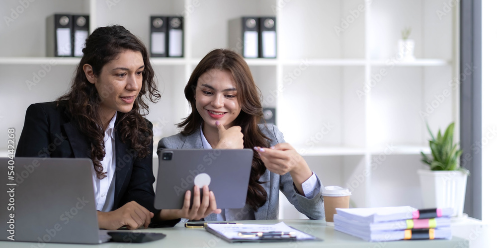 Two young Asian business woman talk, consult, discuss working with new startup project idea presentation analyze plan marketing and investment in the office. Two young Asian business woman talk, consult, discuss working with new startup project idea presentation analyze plan marketing and investment in the office.