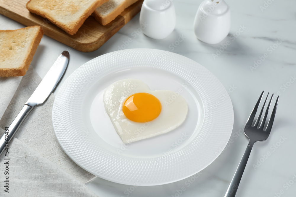 Romantic breakfast with heart shaped fried egg served on white marble table Romantic breakfast with heart shaped fried egg served on white marble table